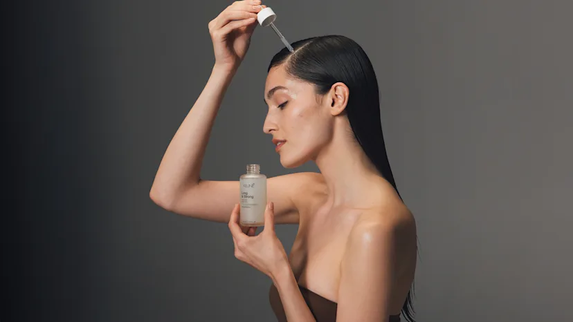 vrouw met lang donker haar dat een serum aanbrengt van Keune